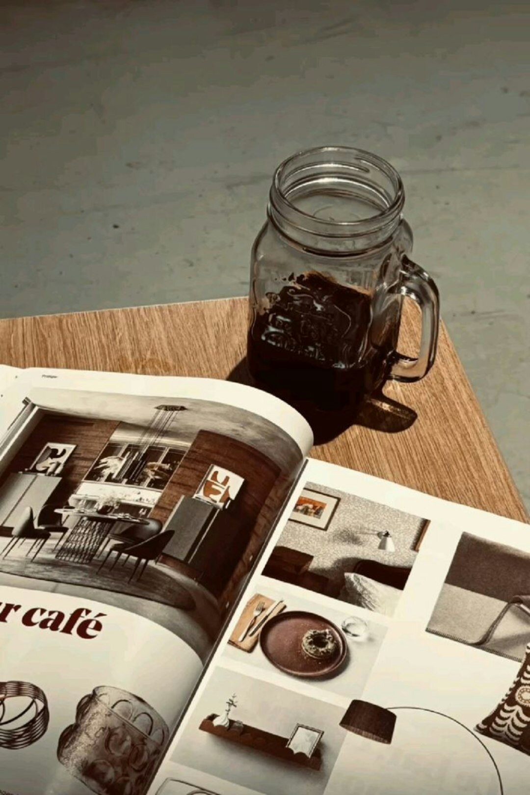 Stack of vintage advertising posters and printed magazines on a wooden table